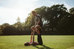 Couple in park practising pair acro yoga