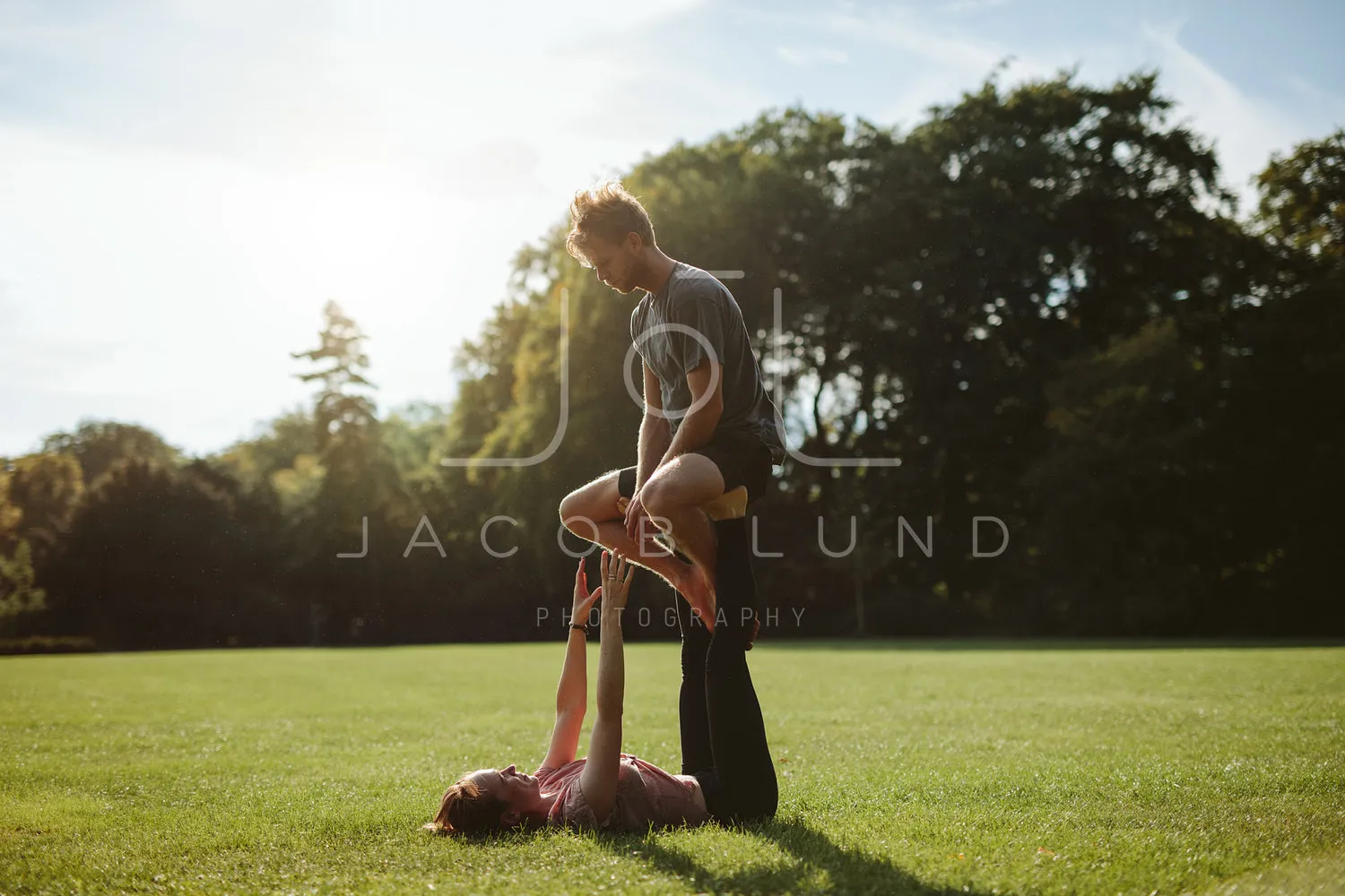 Couple in park practising pair acro yoga